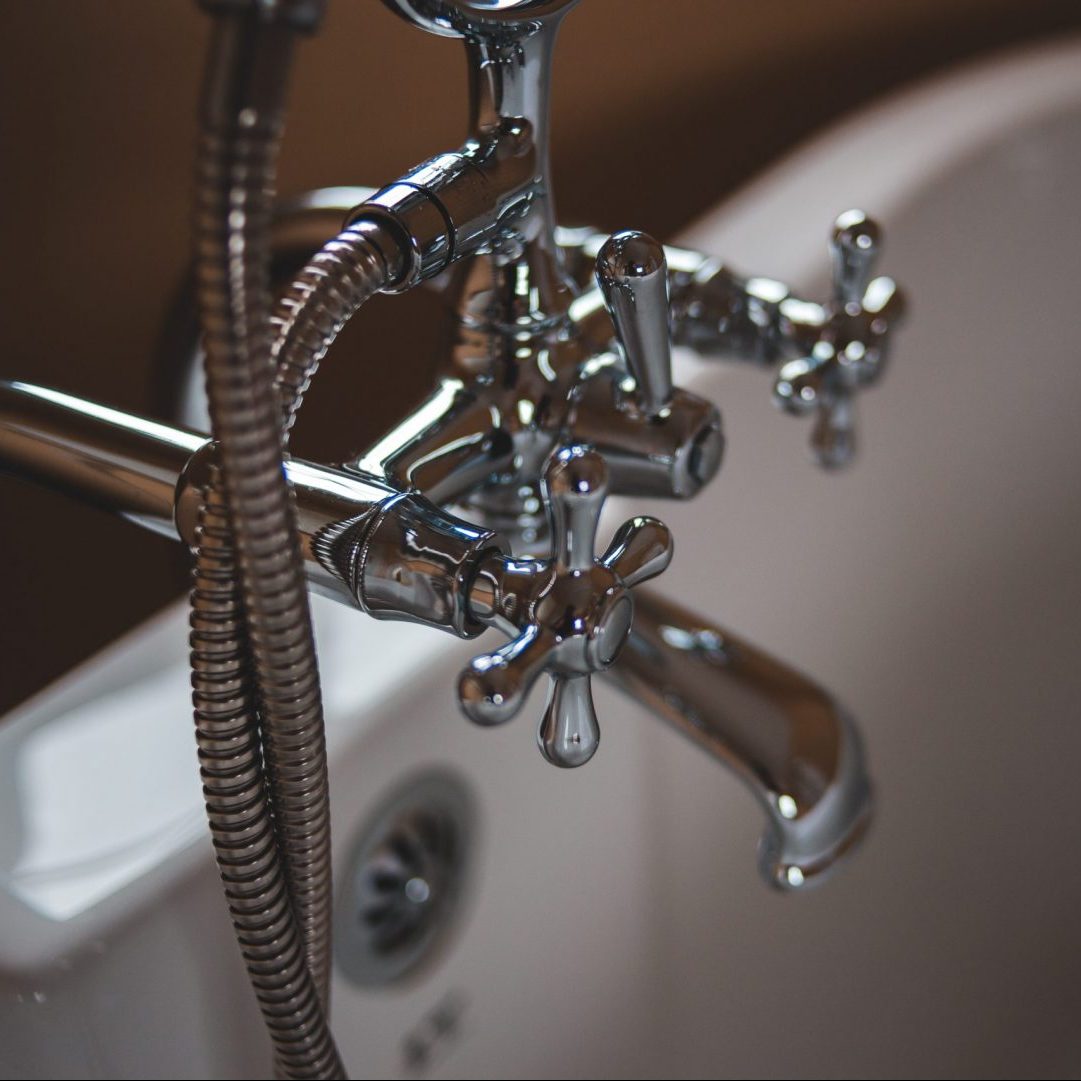 silver water faucet on white ceramic sink